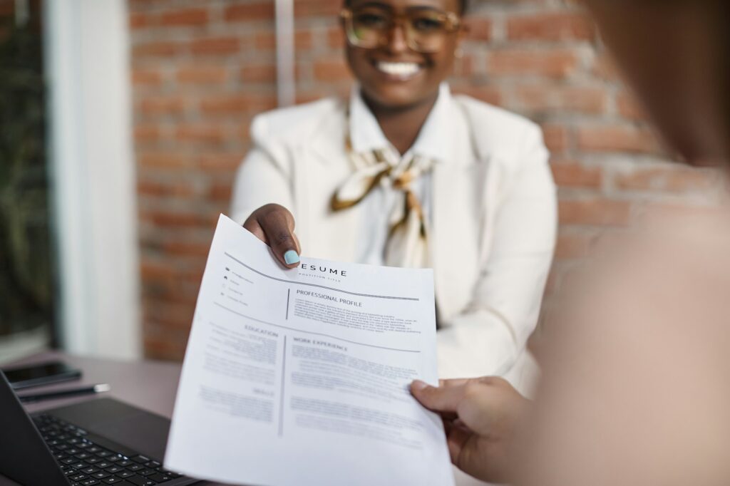 Close-up of black businesswoman giving her resume during job interview in the office.