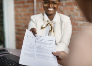 Close-up of black businesswoman giving her resume during job interview in the office.