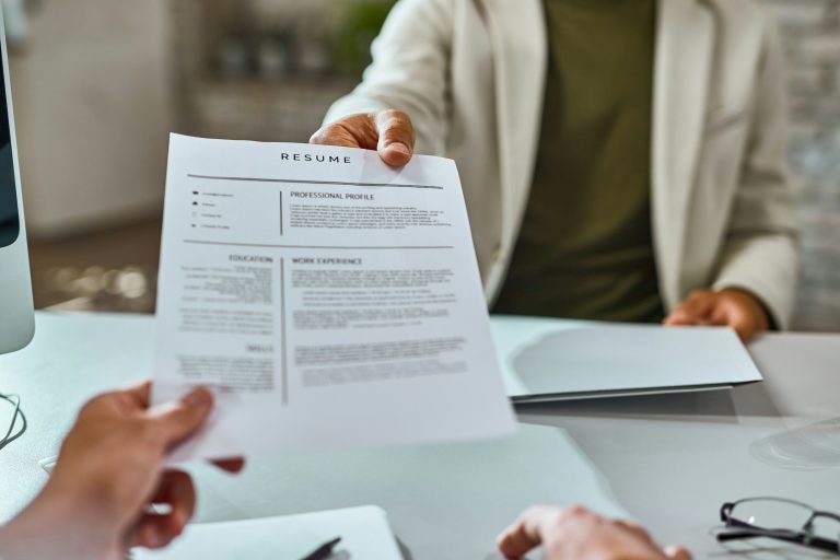 Close-up of candidate giving his CV on a job interview.