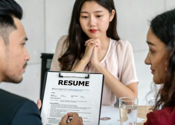 Closeup Resume in two manager hand holding when discuss about her resume with serious motion