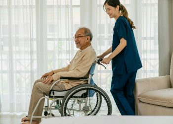 Caregiver assisting a elderly man, symbolizing the development of skills such as organization, time management, and communication, which can be translated onto a resume.