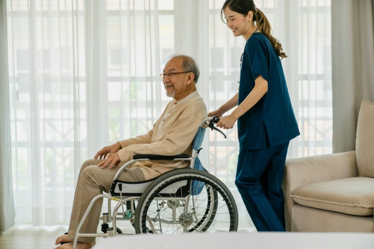 Caregiver assisting a elderly man, symbolizing the development of skills such as organization, time management, and communication, which can be translated onto a resume.