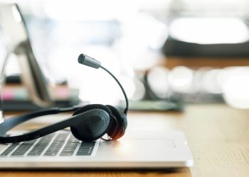 VOIP headset on desk with laptop computer at customer service. call center and helpline concept.