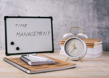 Alarm clock and books - time management and procrastination concept