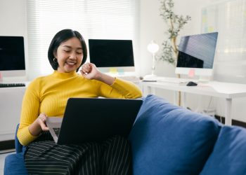 Asian freelancer working on laptop from home office