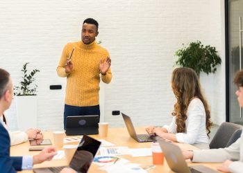 Black male team leader at business meeting in an office, discussing business affairs with other work