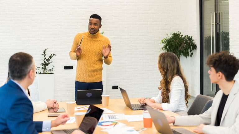 Black male team leader at business meeting in an office, discussing business affairs with other work