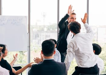 Boss giving high five to employee during conference