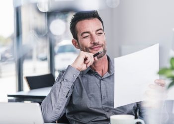 Businessman sitting in office, reading a letter