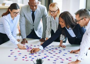 Diverse group of businesspeople working together to solve a puzzle