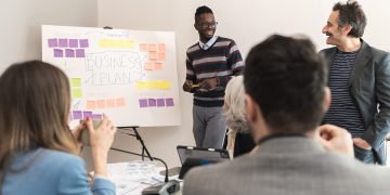 Diverse startup team collaborating on business plan using agile methodology