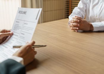 Examiner reading a resume during job interview at office Business and human resources concept