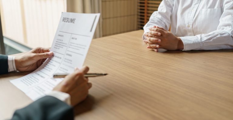 Examiner reading a resume during job interview at office Business and human resources concept