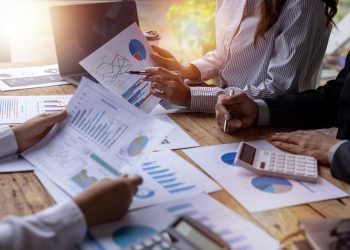 Financial analysts analyze business financial reports on a digital tablet planning investment