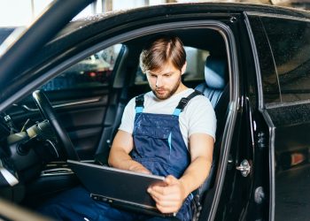 Find an error. A qualified experienced electrician works with a laptop