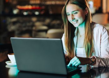 Freelancer sitting in a coffee shop and finishing the online job