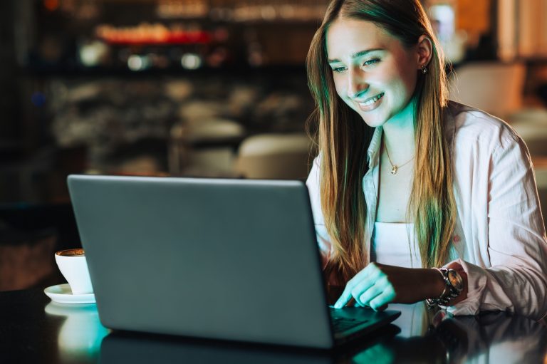 Freelancer sitting in a coffee shop and finishing the online job