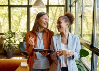 Happy cheerful coworkers chatting at workplace