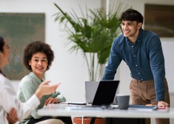Joyful Arabic Businessman Engages in Communication with Coworkers At Workplace
