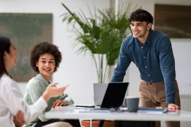 Joyful Arabic Businessman Engages in Communication with Coworkers At Workplace