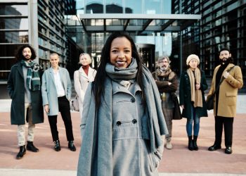 Leading businesswoman standing out from a group of business people while standing together