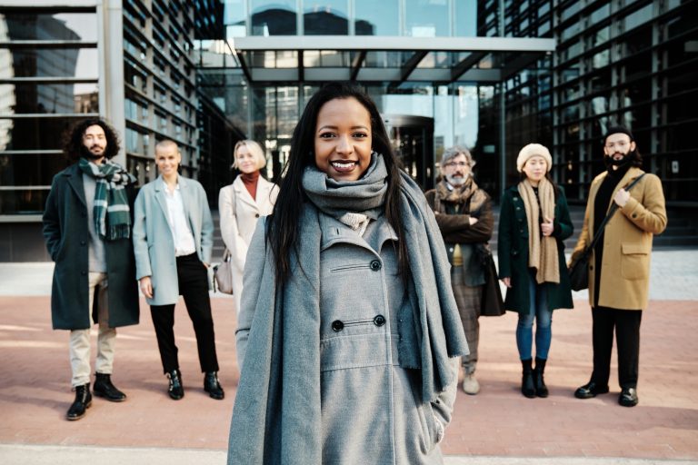 Leading businesswoman standing out from a group of business people while standing together