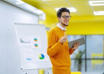 Male business coach speaker giving flipchart presentation