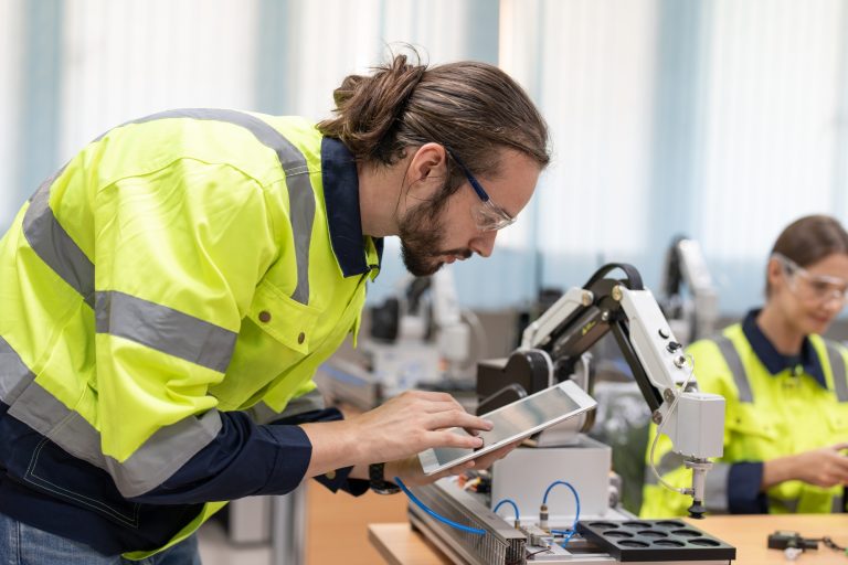 Male engineer using remote testing and control AI robot model in academy robotics laboratory room