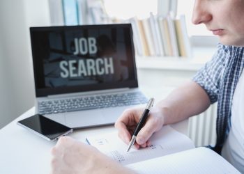 Man writes in organizer meeting date, information on job search, vacancy. Looking for remote work