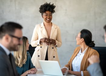 Multicultural professional businesspeople working together on research plan in boardroom.