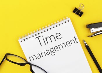 notebook with word time management on a yellow background
