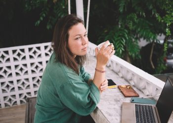 pondering female freelancer with digital laptop computer thinking about blogging