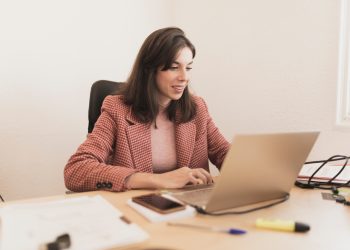 Serious woman using laptop at workplace