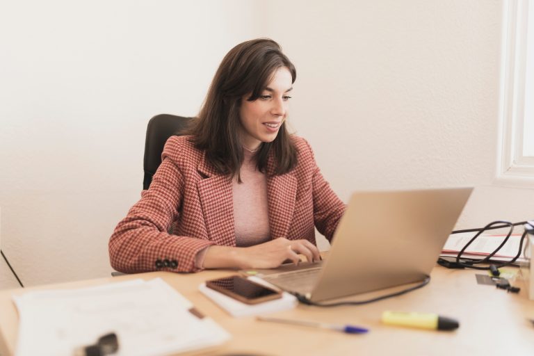 Serious woman using laptop at workplace