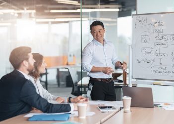 Skilled male business leader coaching interested business people