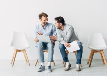 Smiling candidates with laptop and resume waiting for job interview in office