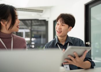 Two Asian Business Colleagues Discussing Work on Tablet. Concept of Collaboration and Communication