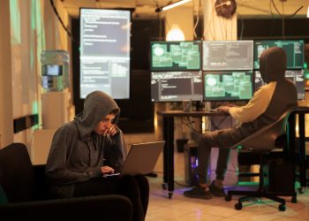 Two hackers working on computers to crack encryption