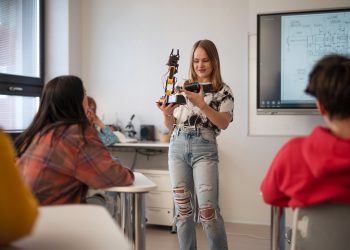 Young High school student is presenting her robotic project in classroom