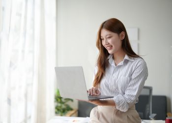 Young professional woman working on a laptop in a modern home office environment