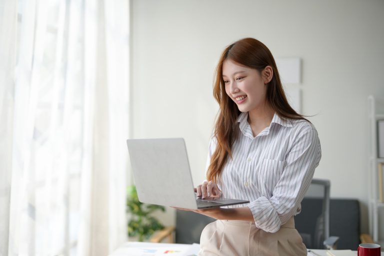 Young professional woman working on a laptop in a modern home office environment