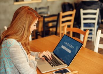 Young woman searching job online in cafe