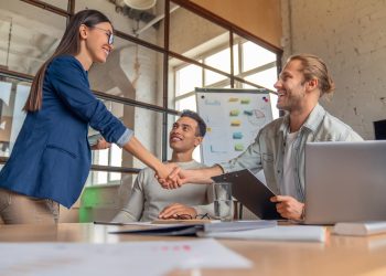 Business people finishing up a meeting. Man shaking hands with female client