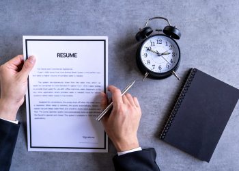 Businessman Analyzing Resume Filling resume on wooden table, Businessman Reading holding resume appl