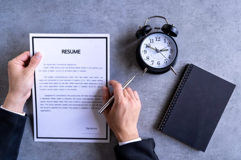 Businessman Analyzing Resume Filling resume on wooden table, Businessman Reading holding resume appl