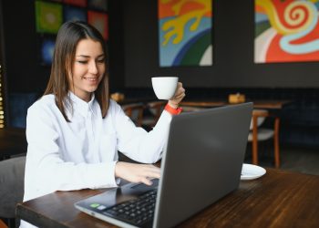 Confident business woman searching resume on site via laptop computer