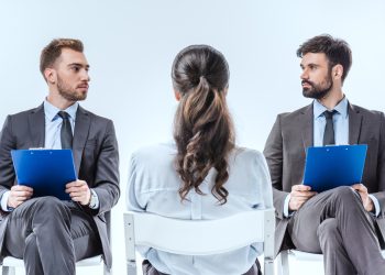 confident businessmen with clipboards looking at each other during job interview
