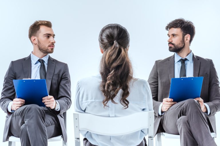 confident businessmen with clipboards looking at each other during job interview