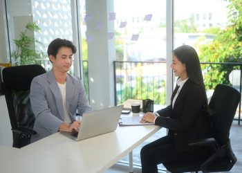 Smiling job applicant answering questions during job interviewing in modern office